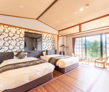 Bright tatami room with twin beds, shoji doors and balcony overlooking greenery at Livemax Resort Yuhigaura Kyoto