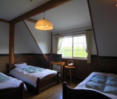 Three single beds in wooden guest room at Lodge Clubman, Iwate Tōhoku with window and small table