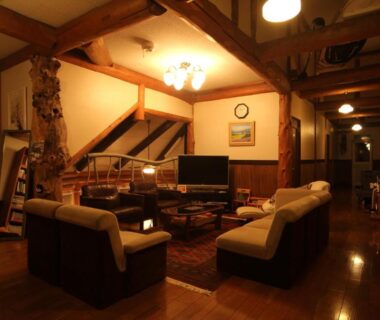 Cozy wooden lounge with sofas, low table and warm lighting at Lodge Clubman in Iwate, Tōhoku