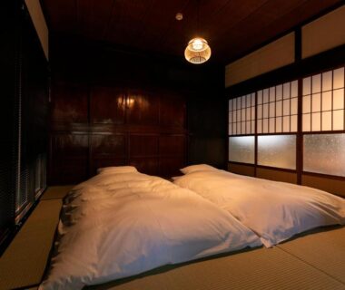 Tatami room with futon bedding, shoji screens and wooden interior at Machihaku 456 in Shizuoka