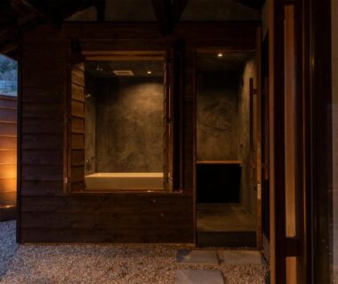Wooden bath area with gravel courtyard and warm lantern lighting at Machihaku 456, Shizuoka