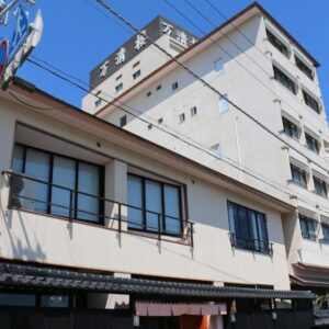 Multi-story ryokan facade with street-level entrance and rooftop signage in Wakayama, Kansai, Japan