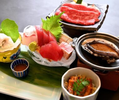 Japanese meal with sashimi, raw beef, simmering shellfish and side dishes at ryokan Manseiro Wakayama