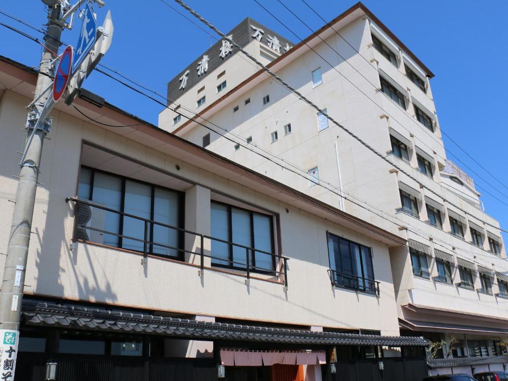 Exterior of Manseiro in Wakayama Multi-story ryokan facade with street-level entrance and rooftop signage in Wakayama, Kansai, Japan