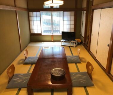 Tatami room with low wooden table, floor cushions and shoji screens at Manten-no-Hoshi in Kanagawa, Kantō, Japan