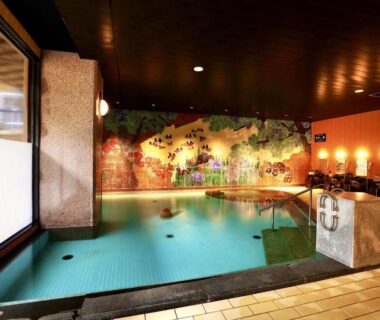 Tiled indoor onsen pool with mural and washing stations at Manten no Tsujinoya, Ishikawa