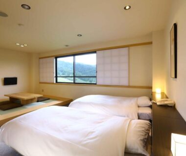 Japanese-style room with twin beds, tatami seating and shoji screens at Manza Onsen Nisshinkan, Gunma Kanto