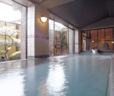 Spacious indoor onsen with large windows overlooking courtyard garden at Maruei in Yamanashi, Chubu Japan