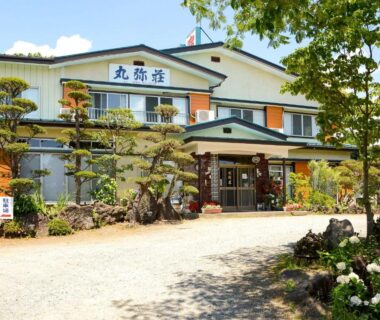 Two-story ryokan facade with pruned garden at Maruyaso in Chūbu Yamanashi, Japan