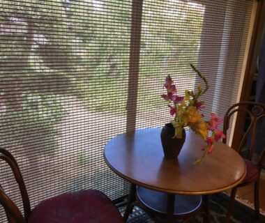 Small round wooden table with flower arrangement by woven window screen at Masugataya Ryokan, Chiba, Kantō