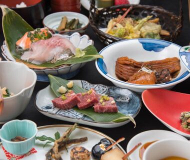Assorted Japanese dishes including sashimi and tempura on lacquerware at Masuya Ryokan in Nagano, Chūbu
