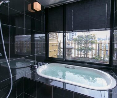Indoor soaking tub with shower and bamboo fence view at Matsui-Bekkan Hanakanzashi Kyoto