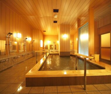 Indoor wooden onsen bath with shower stations and tiled floor at Matsui-Bekkan Hanakanzashi, Kyoto