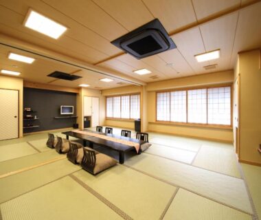 Tatami room with low dining table and cushions at Matsui Honkan in Kyoto