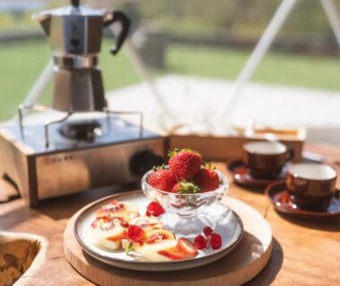 Stovetop coffee maker, cups and a bowl of strawberries on wooden table at Matsukaneya Annex in Yamagata, Tōhoku