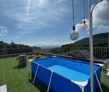 Inflatable rooftop pool on artificial turf with distant mountain views at Matsukaneya Annex, Yamagata