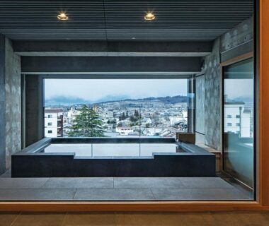 Indoor tiled onsen facing Matsumoto city and distant mountains in Nagano