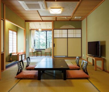 Traditional tatami room with low table, floor cushions, shoji screens and garden view at Matsusaki, Ishikawa