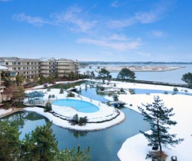 Outdoor resort pools and snowy grounds at Matsushima Ichinobo with bay and pine islets in Miyagi, Tohoku