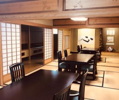 Tatami dining room with long dark tables, chairs, shoji screens and tokonoma at Matsushima Koumura, Miyagi