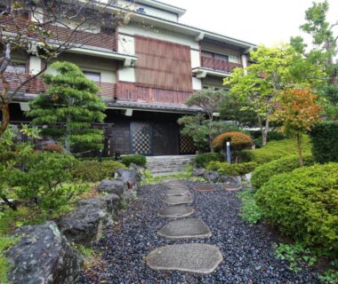 Stepping stone path through manicured garden to traditional wooden ryokan entrance at Matsushima Koumura in Miyagi Tōhoku