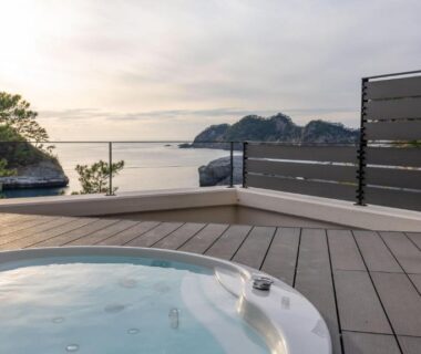 Outdoor circular onsen bath on deck at Mayu Futahari overlooking coastal Shizuoka bay