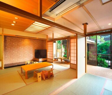 Spacious tatami room with low table, shoji screens and garden-view sliding doors at Meitei no Yado in Yamanashi