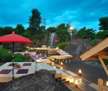 Outdoor garden dining with red parasols at Meitei no Yado Hotel Koshien in Yamanashi, Chūbu