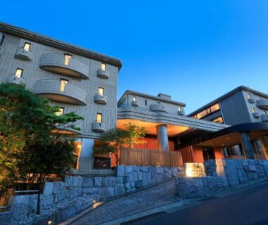 Dusk view of the ryokan facade and illuminated entrance with stone steps in Kanagawa, Japan