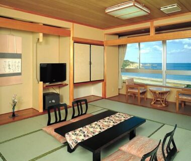 Traditional tatami room with low table, floor chairs and seaside view at Michishio, Mie