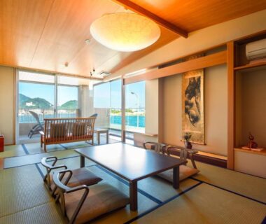 Spacious tatami room with low table, shoji accents, water and mountain view at Migiwaya in Shizuoka, Chūbu Japan