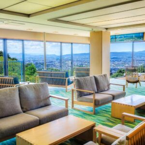 Spacious lounge with sofas and low tables at Mikasa, floor-to-ceiling windows overlooking Nara landscape