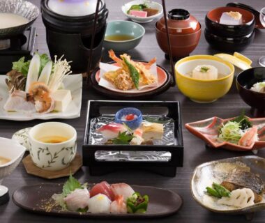 Low table set with assorted Japanese dishes including sashimi, tempura, small bowls, and lacquerware at Mikasa in Nara