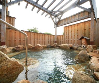 Rock-lined outdoor onsen with wooden fence and pergola roof at Mikasa in Nara, Kansai, Japan