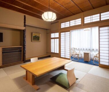 Tatami room with low wooden table, floor cushions and shoji screens at Mikuniya in Hyōgo Kansai