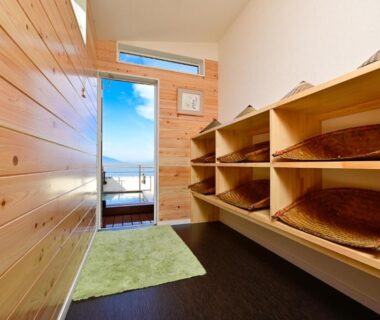 Wooden entryway with cubby shelves and baskets, view toward balcony and distant mountains at Mimatsukan, Gunma, Kantō, Japan