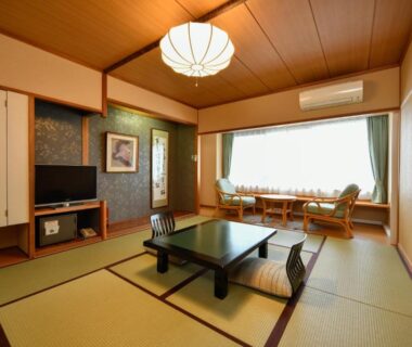 Traditional tatami room with low table, zabuton chairs and window seating at Mimatsukan in Gunma
