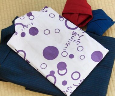 Folded patterned yukata and blue jacket on tatami mat inside Minshuku Fukufuji, Tochigi