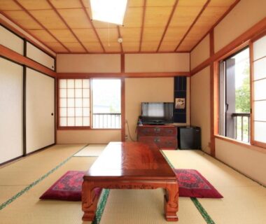 Bright tatami room with low wooden table, floor cushions, shoji screens and sliding fusuma at a Minshuku in Tochigi