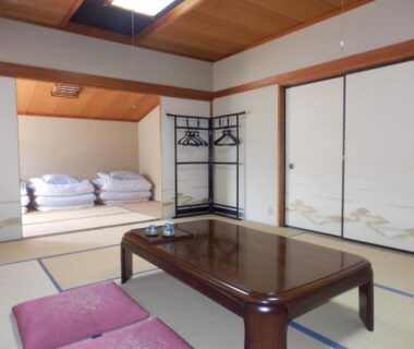 Tatami room with low table, zabuton cushions and folded futons at Minshuku Ginmatsu, Ishikawa, Chūbu, Japan