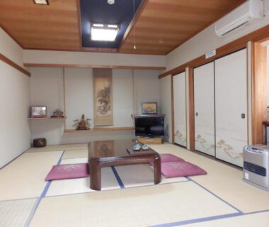 Traditional tatami room with low table, cushions, tokonoma alcove and sliding fusuma doors at Minshuku Ginmatsu Ishikawa Japan