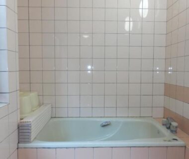 Small tiled bathing area with pale pink tiles and built-in tub at Minshuku Ginmatsu, Ishikawa, Chūbu