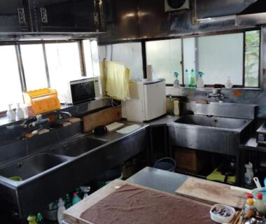 Stainless steel sinks and prep counter in shared kitchen at Minshuku Kamagari, Chūgoku Hiroshima