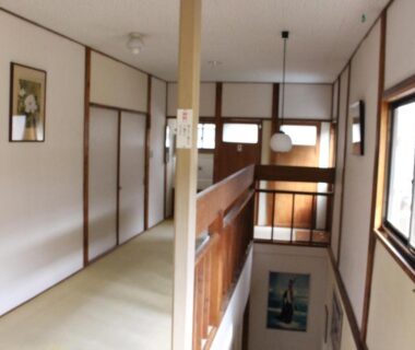 Second-floor corridor with tatami mat, wooden railing, sliding screens and windows at Minshuku Katsuya Wakayama