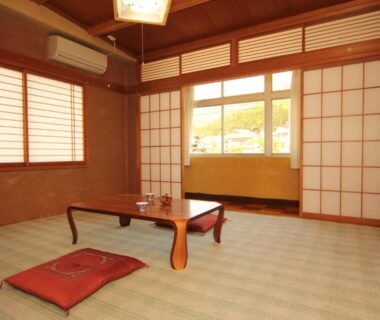 Traditional tatami room with low wooden table, zabuton cushion and shoji screens at Minshuku Miyama, Nagano