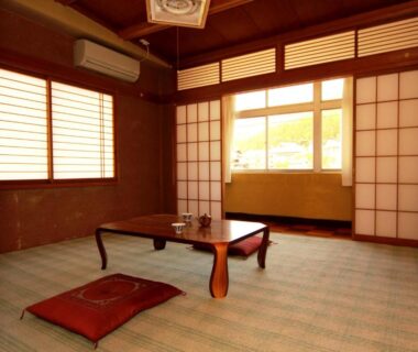 Tatami room with low wooden table, floor cushion and shoji screens at Minshuku Miyama, Nagano