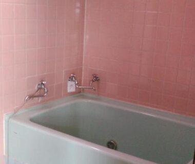 Compact pink-tiled soaking tub with bath products at Minshuku Takahashi Kashibuneten in Shizuoka Chūbu