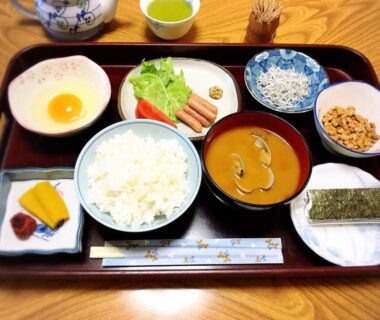 Traditional breakfast tray with rice, soup, raw egg, pickles, seaweed and small side dishes at Minshuku Takahashi Kashibuneten