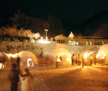 Night scene of illuminated snow domes and visitors near Minshuku Takizawa in Gifu