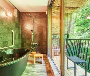 In-room bathtub and shower opening to a forested balcony at Misenkan in Nara, Kansai, Japan
